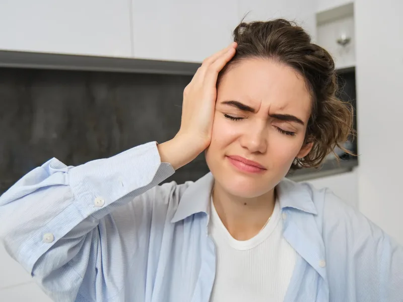 Person holding their head with light and screen sensitivity after a concussion