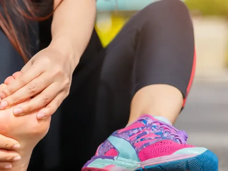 Runner holding a painful foot and ankle