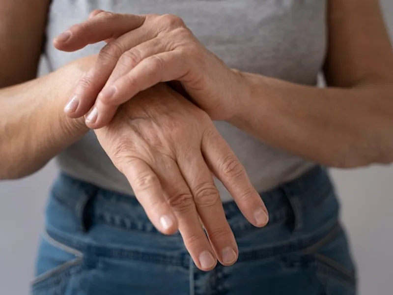 Person holding a painful hand and wrist
