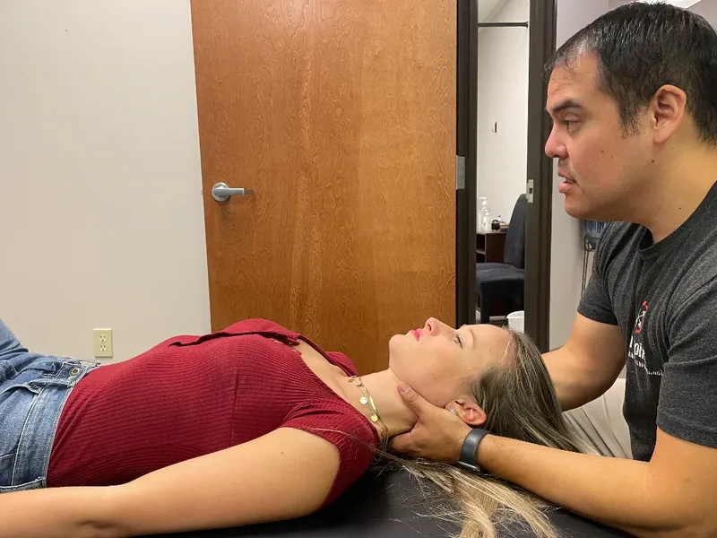 Therapist assessing a patient's neck during a first evaluation