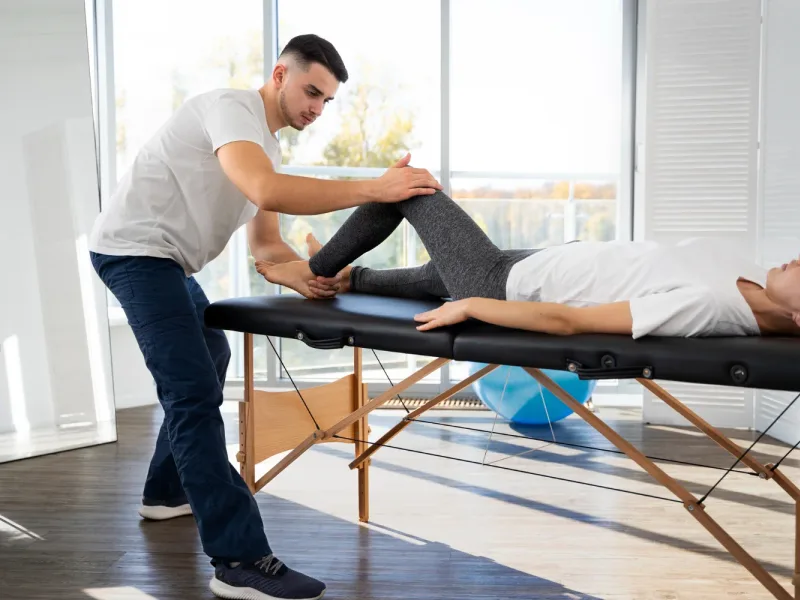 Physical therapist guiding a patient through a leg mobility evaluation