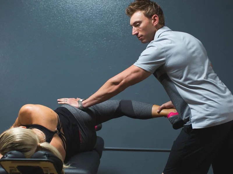 Therapist guiding a patient through an assisted stretch
